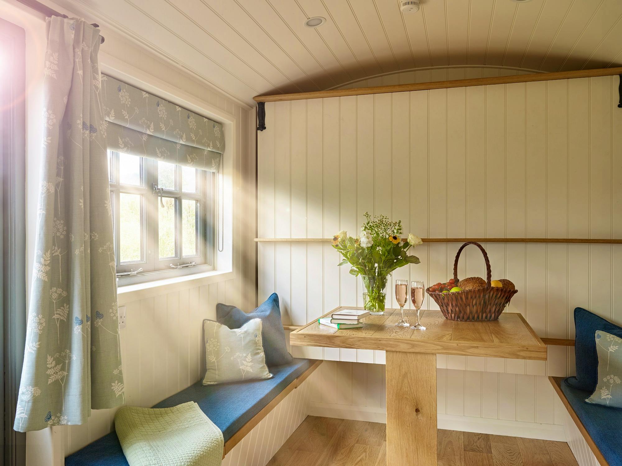 Elm Retreat shepherds hut with bed folded up and dining table in use