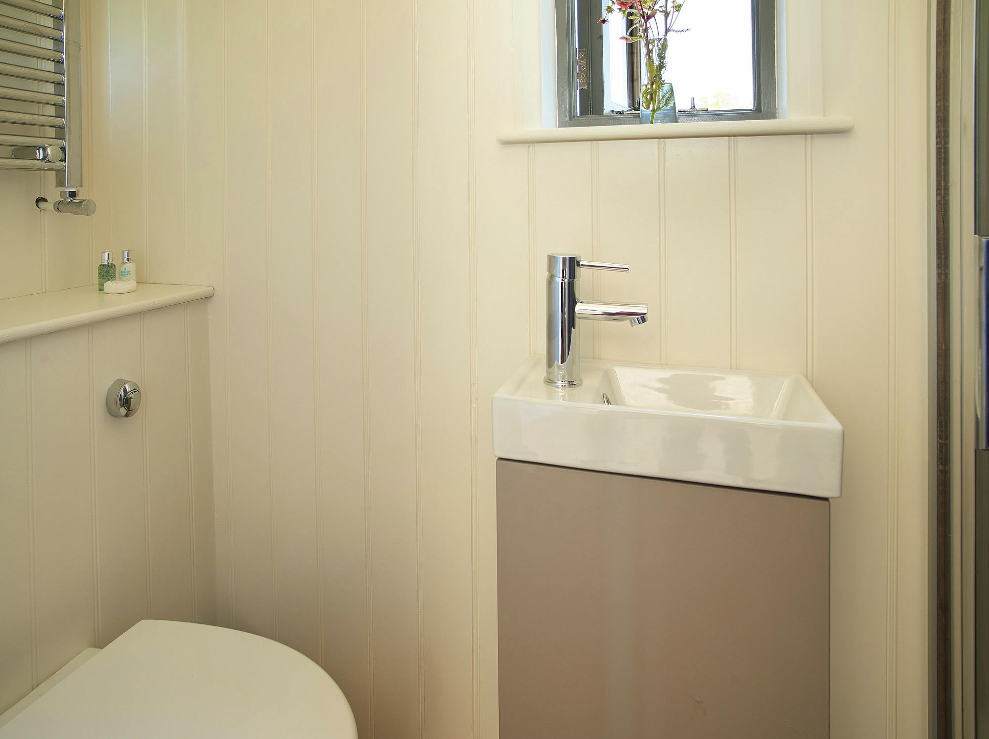 Ensuite shower room with water flushing toilet and chrome towel rail radiator - LPG heating and hot water