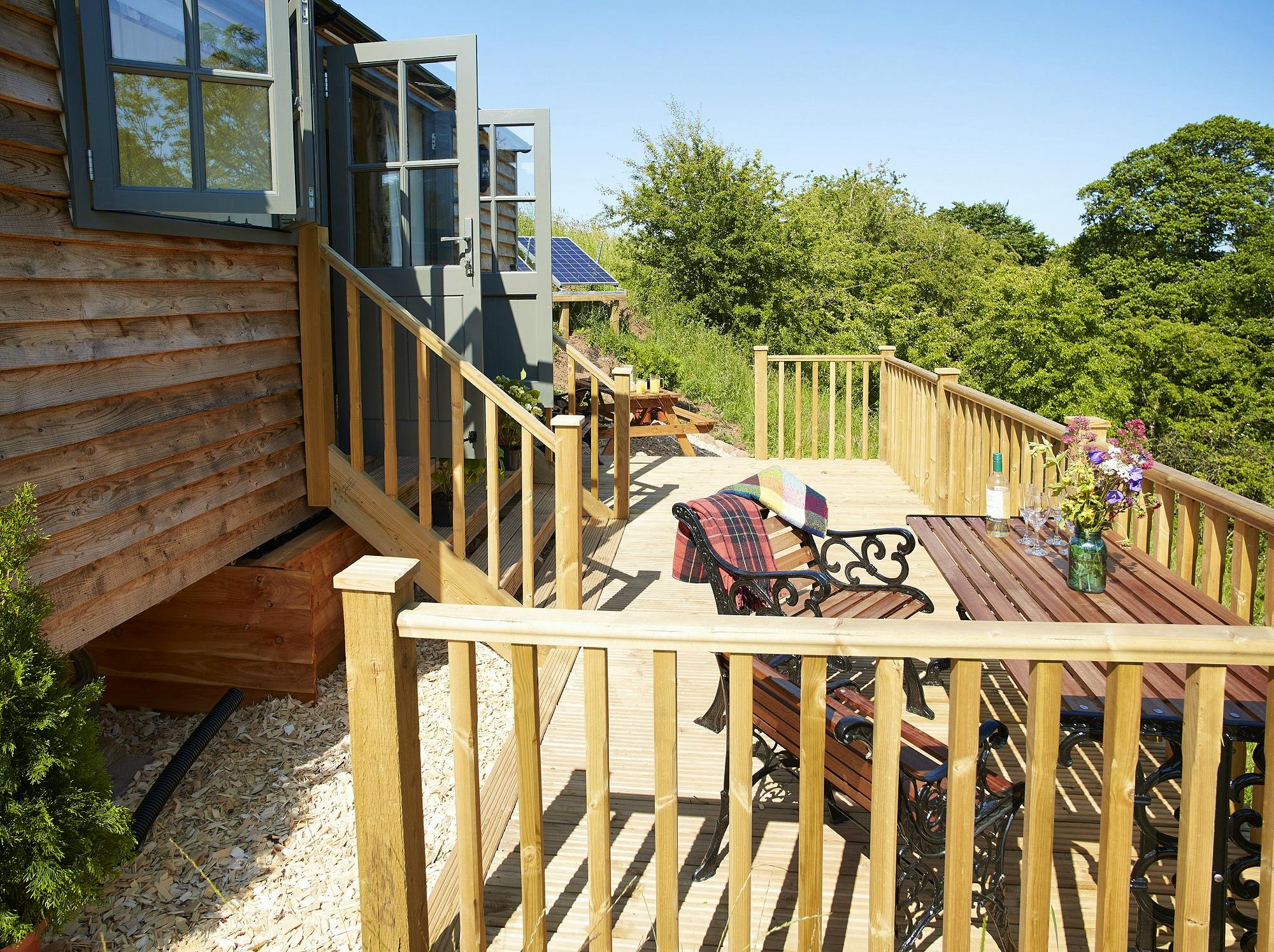 Hawthorn Retreat private balcony with Weber BBQ, fire pit and Adirondack chairs, LPG heating and hot water, solar power