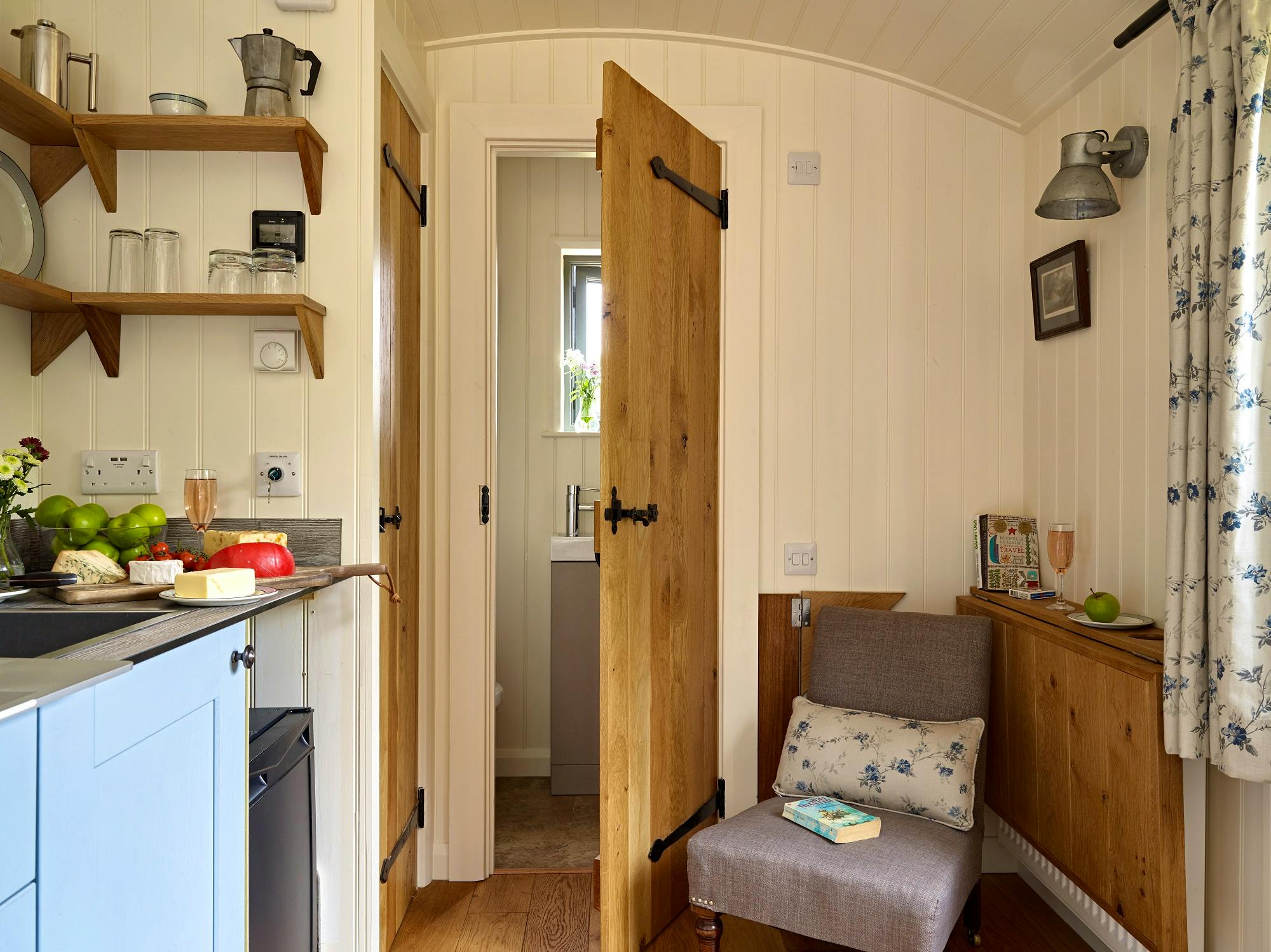 Rowan Retreat shepherds hut with ensuite shower room with water flushing toilet with LPG hob, oven and fridge and LPG heating with chrome towel rail and solar power