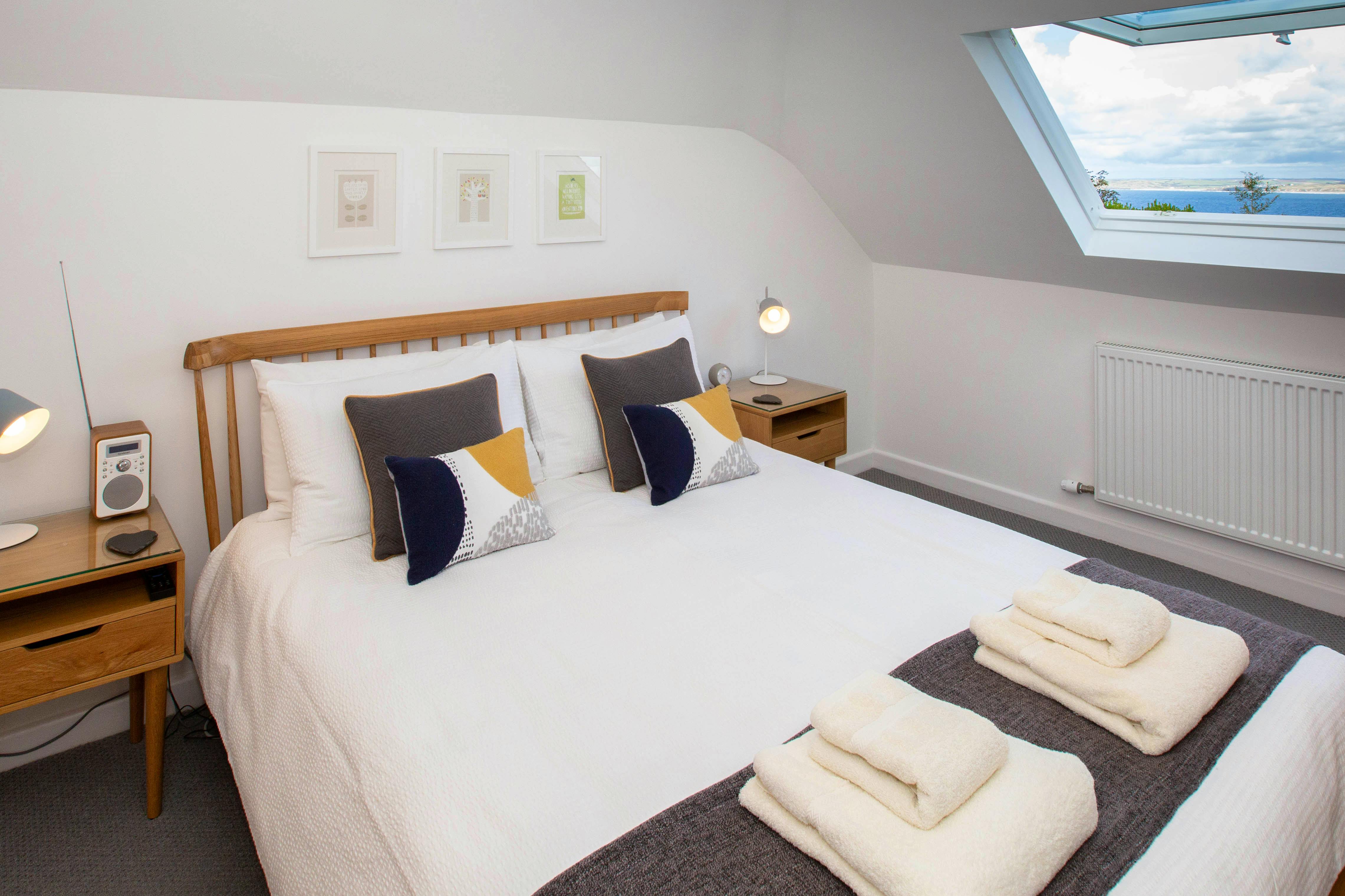 The master bedroom with oak king-size bed and views over the bay