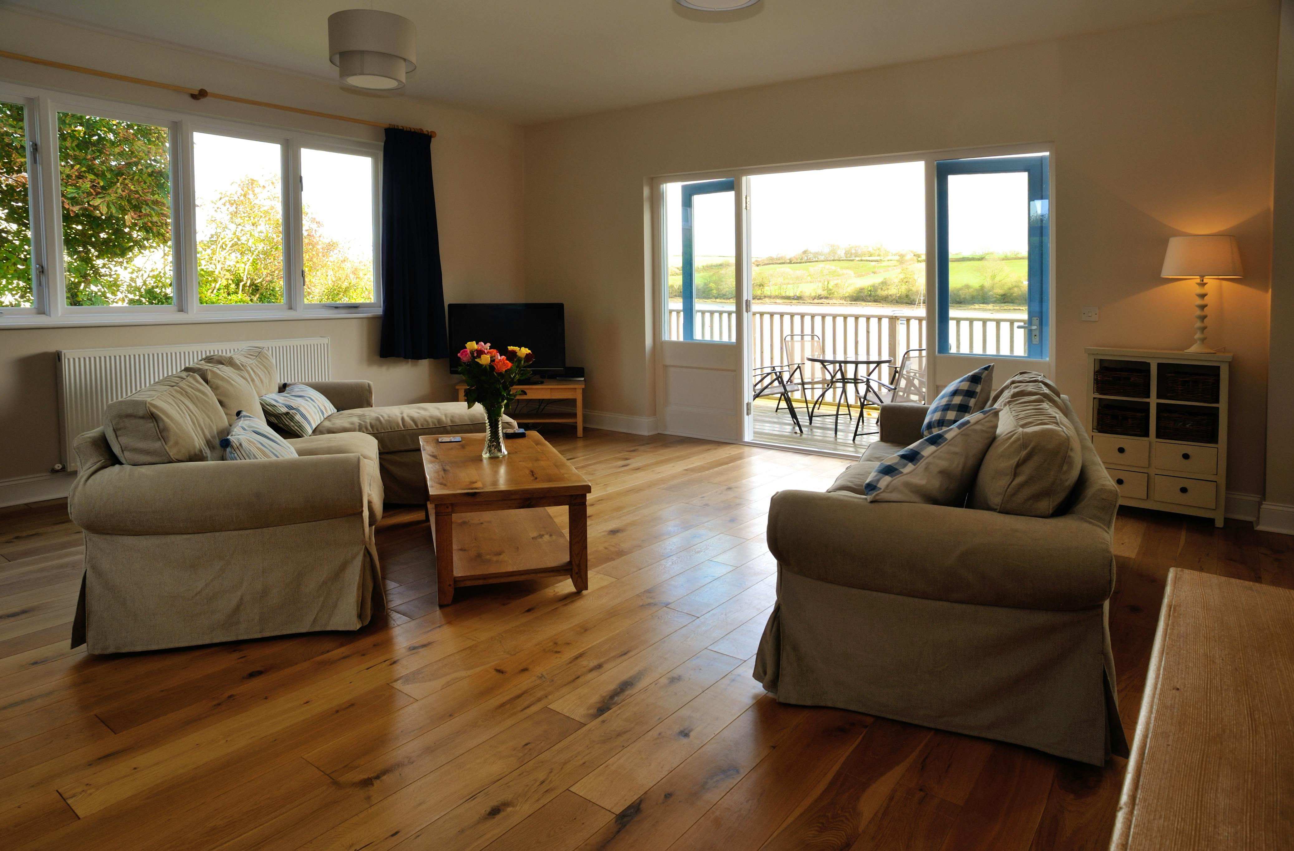 The sitting room with doors on to the decking and views across the estuary