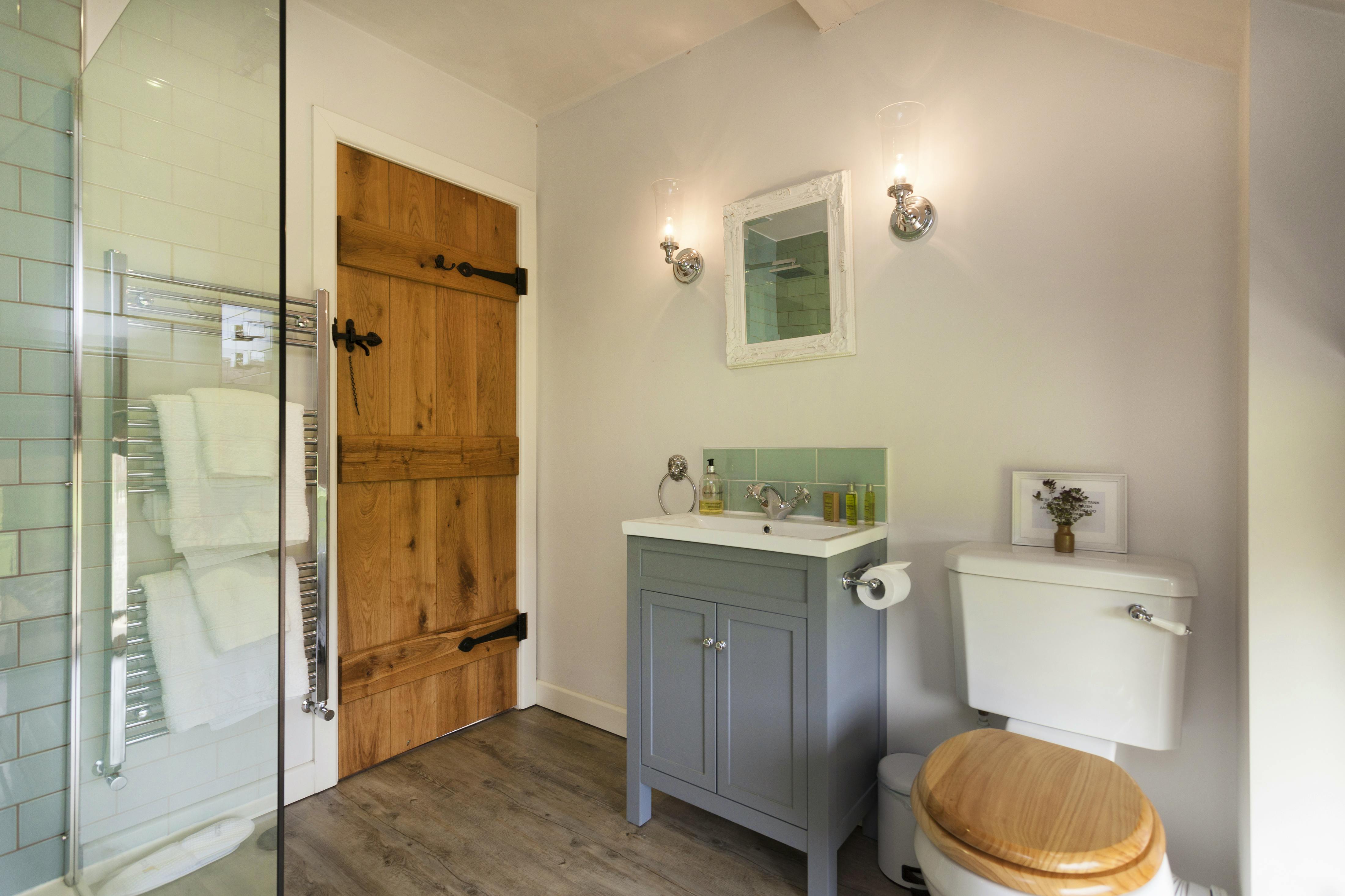 Ensuite shower room with walk in rain shower, heated towel rail and fluffy towels and robes