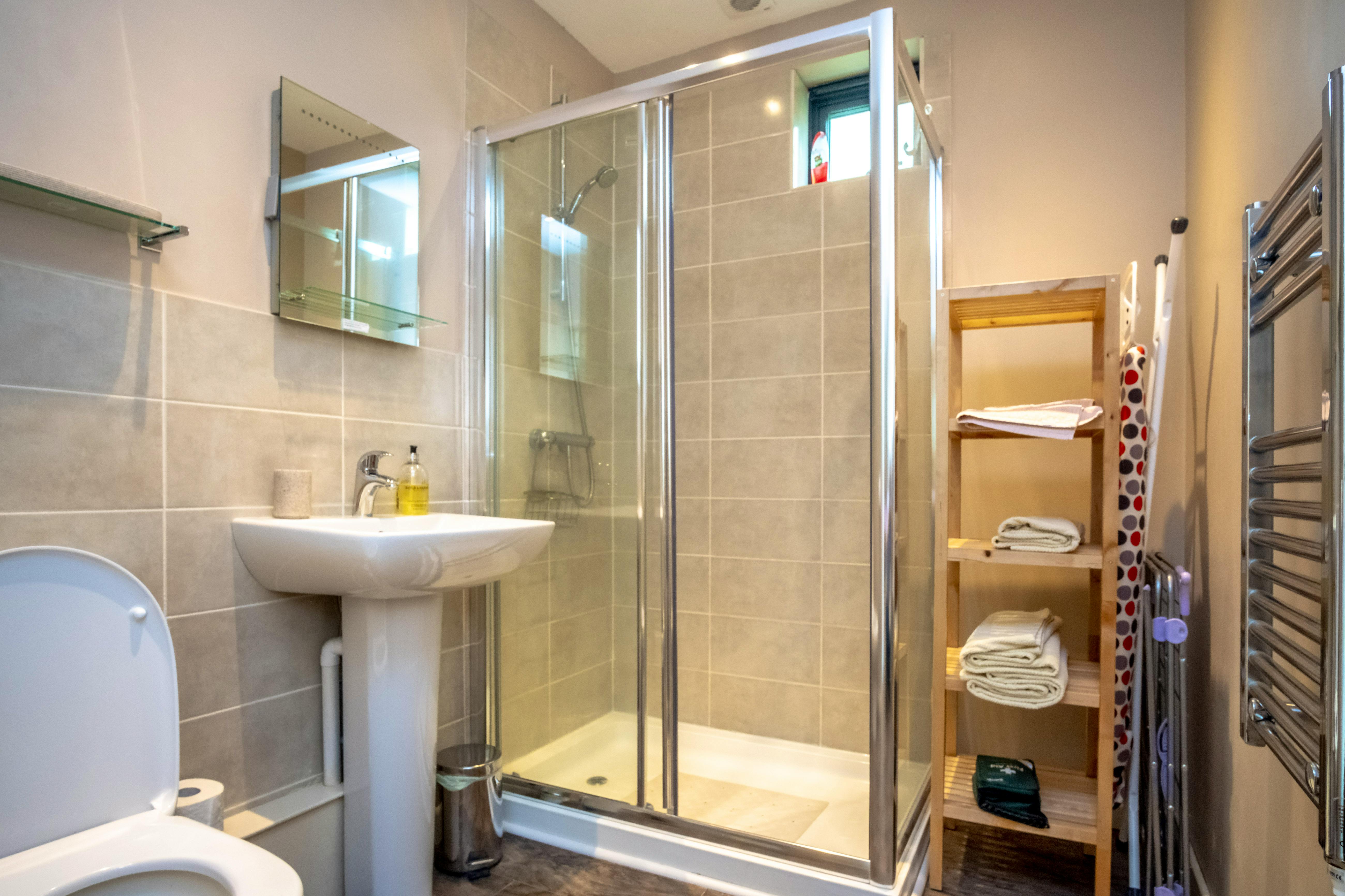 Large shower cubicle and lit mirror